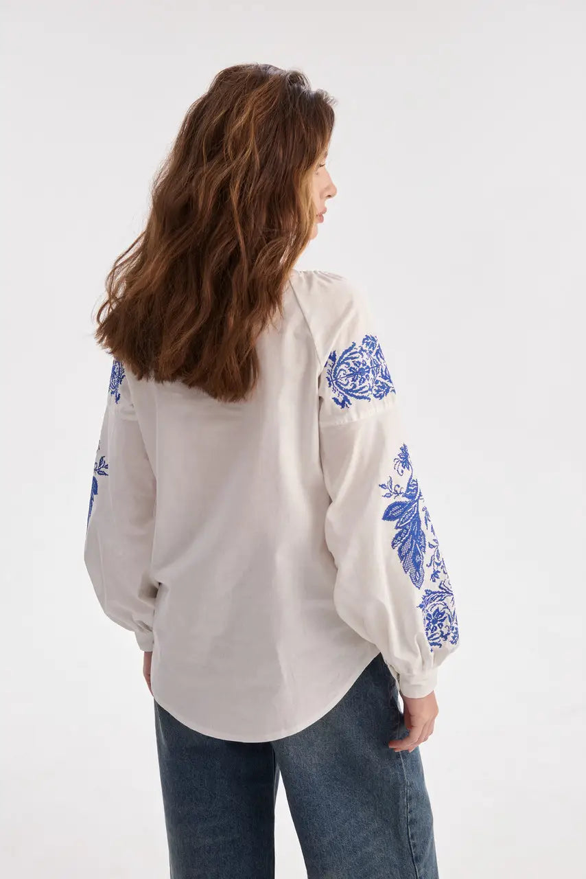 Bluse mit blauer Stickerei in Milchweiß